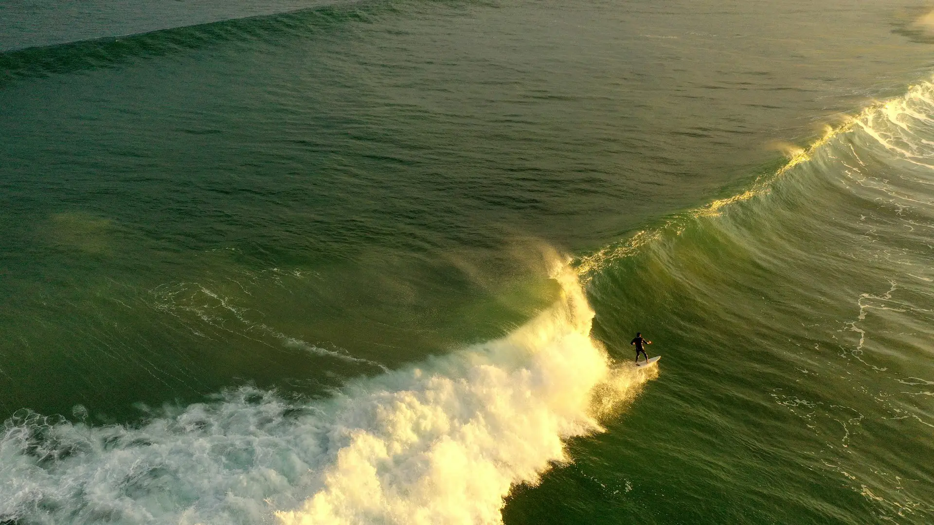 Un hombre surfeando una gran ola en Zarautz, el País Vasco